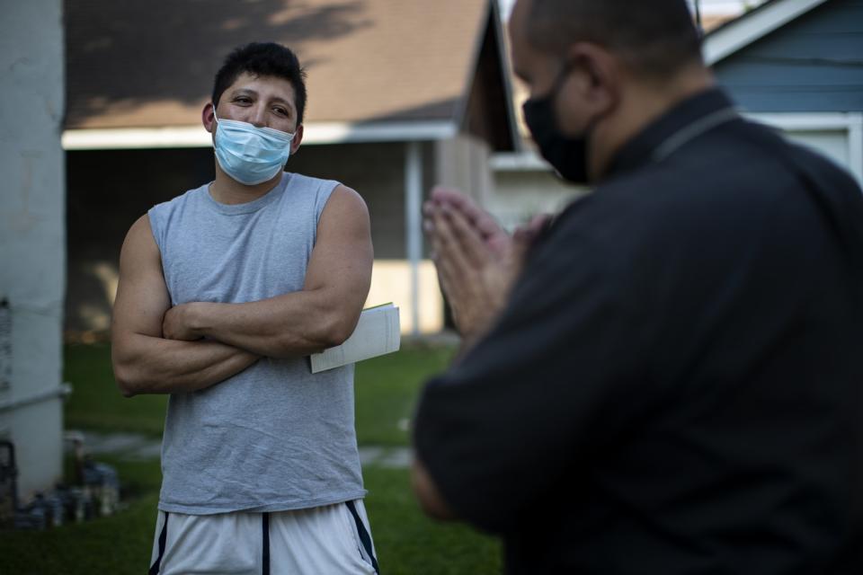 The Rev. Nelson Rabell-González blesses farmworker Cristobal Rodriguez after he got a $1,000 check to help cover expenses