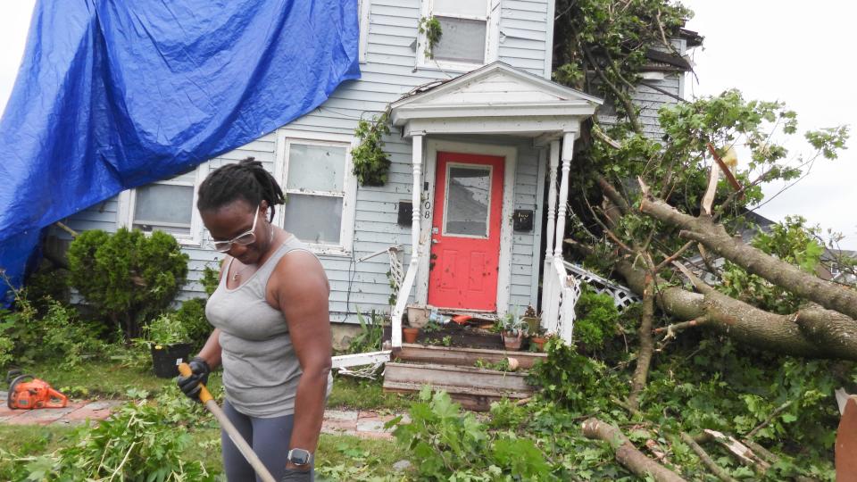 Rome resident Sharon Samuels rakes debris from trees toppled near her home on West Embargo Street.