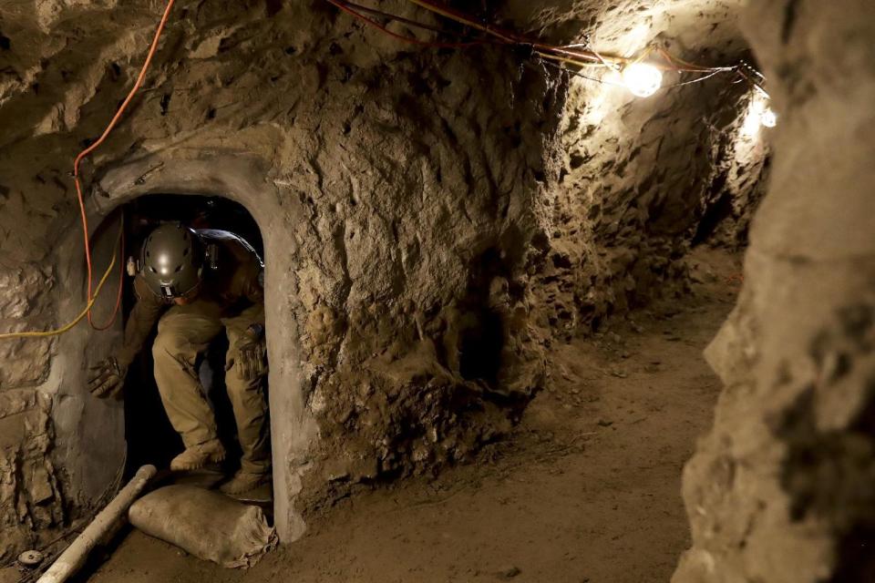 In this March 6, 2017 photo, a member of the Border Patrol's Border Tunnel Entry Team enters a tunnel spanning the border between San Diego and Tijuana, Mexico, in San Diego. They are known in the Border Patrol as "tunnel rats" - agents who go in clandestine passages that have proliferated on the U.S.-Mexico border over the last 20 years to smuggle drugs. (AP Photo/Gregory Bull)