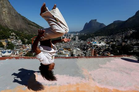 A member of the Acorda Capoeira (Awaken Capoeira) group performs on a rooftop in the Rocinha favela in Rio de Janeiro, Brazil, July 24, 2016. REUTERS/Bruno Kelly