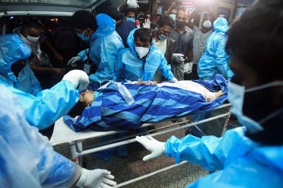 Health workers transfer an inured passenger on a stretcher to take her inside a hospital in Kozhikode, Kerela, after an Air India Express jet crashed by overshooting the runway at Calicut International Airport, on August 7, 2020. - At least 19 people died when a passenger jet skidded off the runway after landing in heavy rain in India, police said on August 7. (Photo by - / AFP) (Photo by -/AFP via Getty Images)