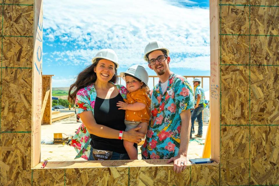 Avonlea and Buck Ide and their infant son celebrate as the wall is raised for their new home in Hayden Home’s River North community in Benton City. The family was selected to participate in the builder’s First Story program, which includes a zero-down, zero-interest mortgage on a new house.