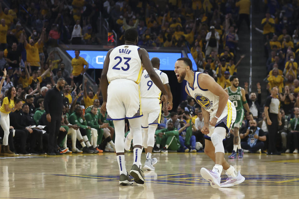 Golden State Warriors guard Stephen Curry, right, celebrates with forward Draymond Green (23) during the first half of Game 1 of basketball's NBA Finals against the Boston Celtics in San Francisco, Thursday, June 2, 2022. (AP Photo/Jed Jacobsohn)