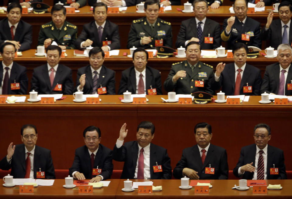 Chinese Vice President Xi Jinping, center in front row, keeps his hand up during a show of approval for a work report during the closing ceremony for the 18th Communist Party Congress at the Great Hall of the People in Beijing Wednesday Nov. 14, 2012. (AP Photo/Ng Han Guan)