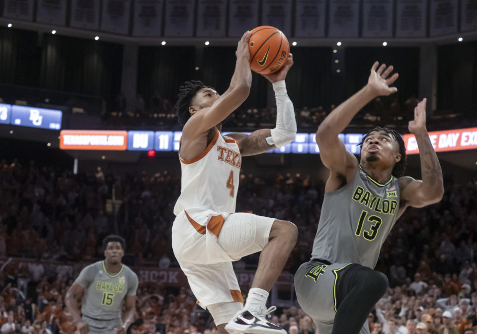 Texas guard Tyrese Hunter (4) drives to the basket as Baylor guard Langston Love (13) in the closing second of the second half of an NCAA college basketball game, Saturday, Jan 20, 2024, in in Austin, Texas. Hunter’s driving layup at the buzzer sent Texas to 75-73 win over No. 9 Baylor. (AP Photo/Michael Thomas)