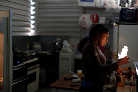 Honduran migrant Erly Marcial, 21, prepares a meal for her son Alvin, in the kitchen of a church where they are staying in Tijuana, Mexico, December 9, 2018. REUTERS/Carlos Garcia Rawlins