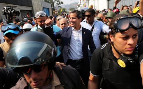 Venezuela's self-proclaimed president Juan Guaido greets supporters during an attempted military uprising in Caracas - Credit: AP Photo/Fernando Llano