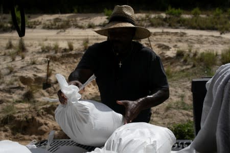 A man loads a truck with sand bags ahead of the arrival of Hurricane Dorian in Titusville