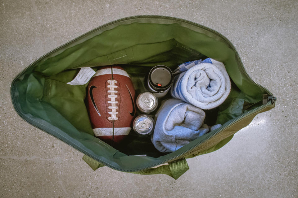 interior of LL Bean tote bag with a football, cans and towels