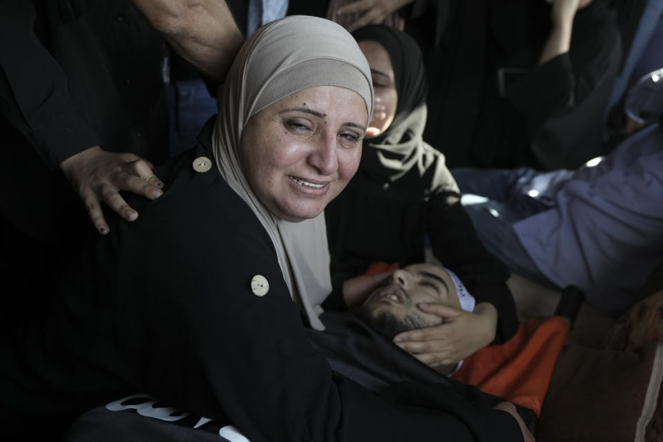 Sozi Lahlouh, mother of Palestinian Bara Lahlouh, 24, mourns next to his body, during the funeral at his family home in the West Bank town of Jenin, Friday, June 17, 2022. Israeli forces shot dead Lahlouh and another two Palestinians and wounded eight others early Friday during a military operation in the occupied West Bank town of Jenin, the Palestinian Health Ministry said. The military said the troops traded fire with militants. (AP Photo/Nasser Nasser)