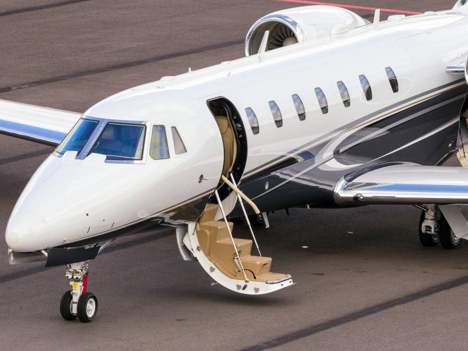 A white Citation Sovereign with boarding door open.