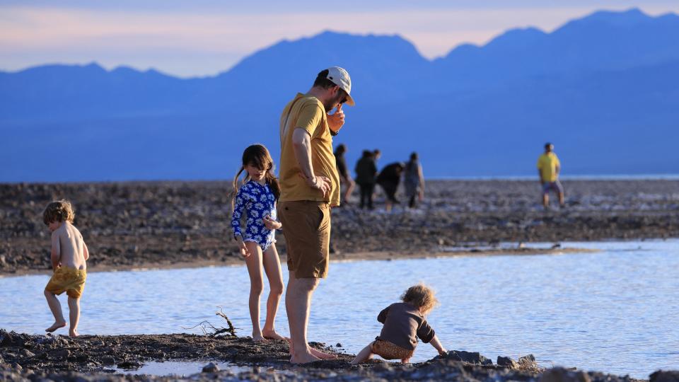 Tourists enjoy the rare opportunity to walk in water as they visit Badwater Basin, the normally driest place in the US