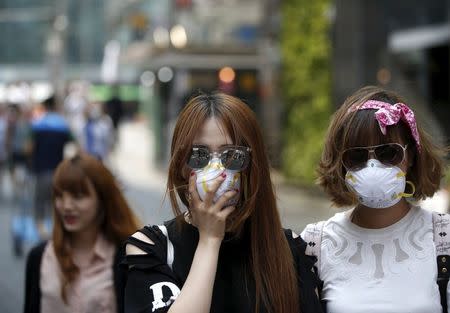 Tourists wearing masks to prevent contracting Middle East Respiratory Syndrome (MERS) walk at Myeongdong shopping district in central Seoul, South Korea, June 12, 2015. REUTERS/Kim Hong-Ji