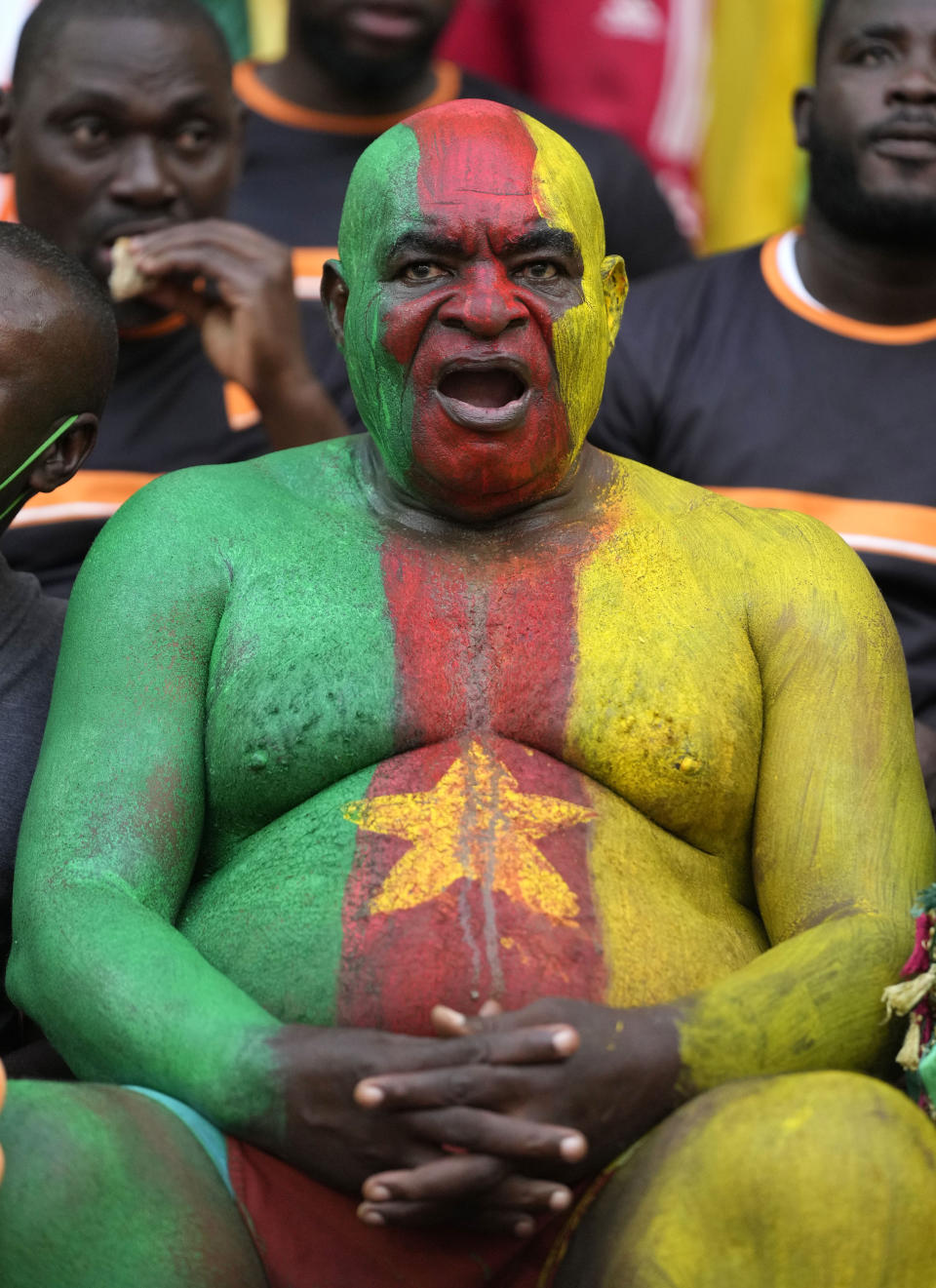 FILE- A man painted in the colours of the Cameroon flag, chants, prior to the African Cup of Nations Group D soccer match between Cameroon and Ivory Coast, at Estadio De Malabo, in Malabo, Equatorial Guinea, on Jan. 28, 2015. (AP Photo/Sunday Alamba, File)