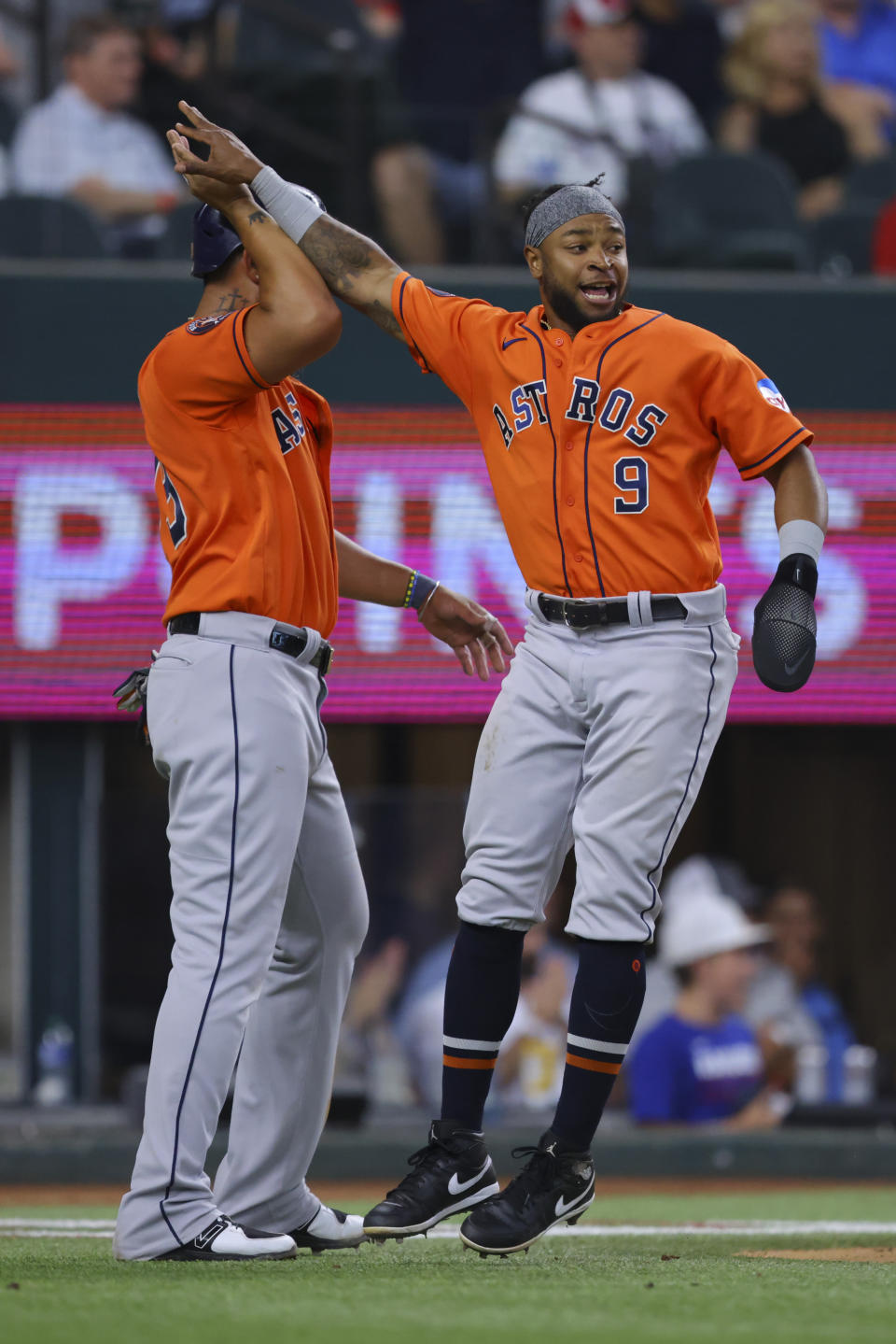 Houston Astros José Abreu, left, and Corey Julks, right, celebrate scoring on a triple from Chas McCormick in the eighth inning of a baseball game against the Texas Rangers, Sunday, July 2, 2023, in Arlington, Texas. (AP Photo/Gareth Patterson)