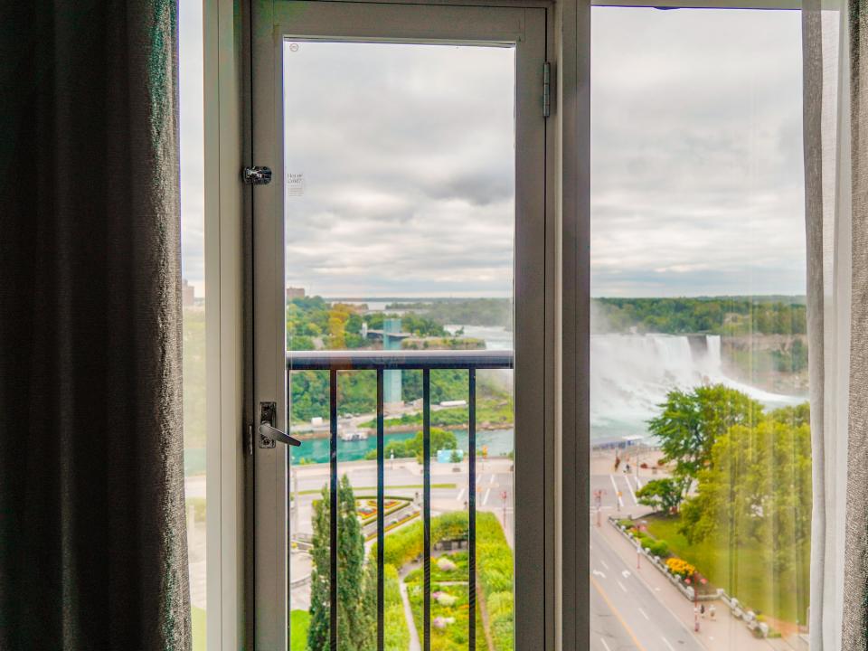 A window in a hotel room overlooking Niagara Falls