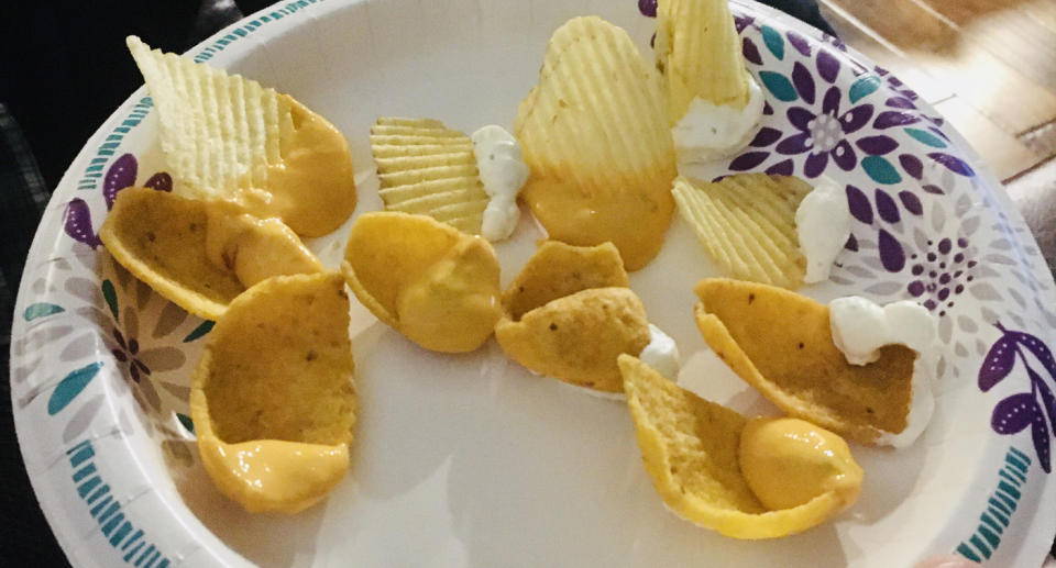 A plate full of chips that have been re loaded with dip