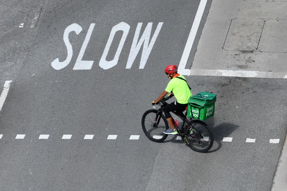 A delivery cyclist rides across a road junction in Singapore. 