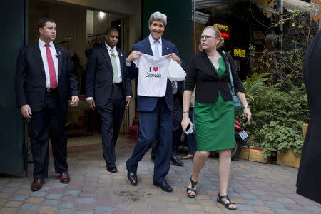 U.S. Secretary of State John Kerry holds "I love Cambodia" t-shirt that he bought for his grandchild as he walks out of the souvenir shop in Phnom Penh, Cambodia, January 26, 2016. REUTERS/Jacquelyn Martin/Pool