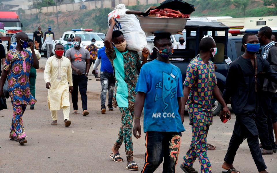 People wear face masks ahead police checkpoint in compliance with state directive to curb the spread of COVID-19 coronavirus at Ojodu-Berger in Lagos - AFP 