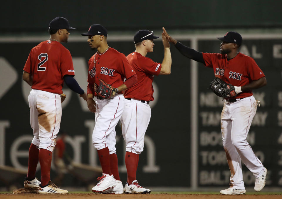 Boston Red Sox's Xander Bogaerts, Mookie Betts, Brock Holt and Jackie Bradley Jr., from left, celebrate the team's 8-1 victory over the Los Angeles Dodgers in a baseball game at Fenway Park, Friday, July 12, 2019, in Boston. (AP Photo/Elise Amendola)