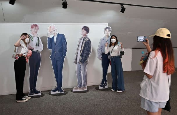 PHOTO: Visitors pose with card board cut outs of K-pop group BTS members for their souvenir photos at a tourist information centre in Seoul on June 15, 2022. (Jung Yeon-je/AFP via Getty Images)