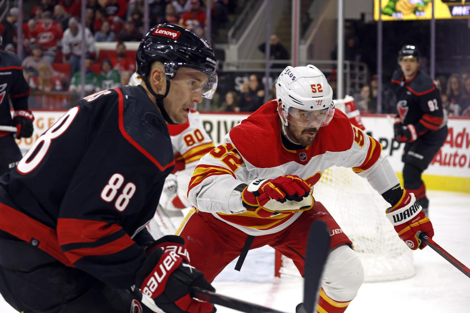 Calgary Flames' MacKenzie Weegar (52) chases the puck with Carolina Hurricanes' Martin Necas (88) during the second period of an NHL hockey game in Raleigh, N.C., Sunday, March 10, 2024. (AP Photo/Karl B DeBlaker)