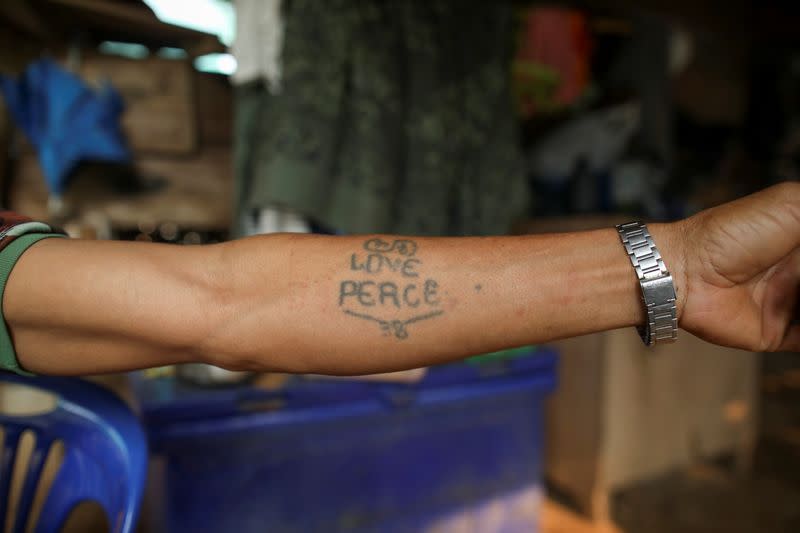 Izzie, 49, former Karenni Army (KNPP) soldier shows his tattoo in the Kayan village in Mae Hong Son