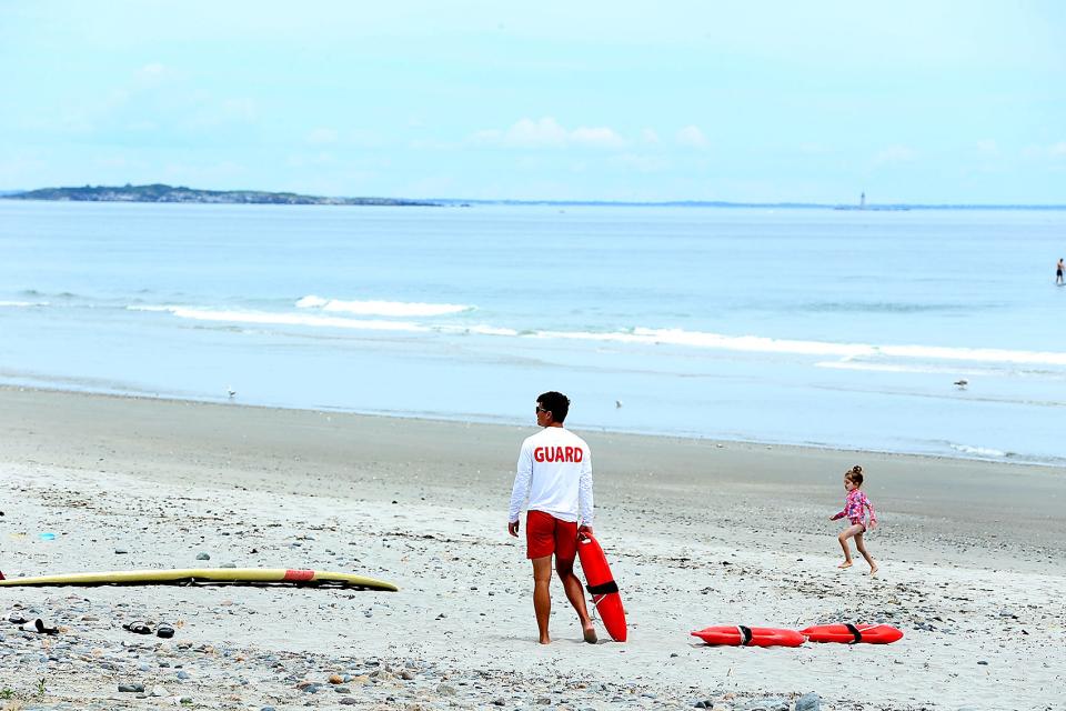 Lifeguard James Mahoney, of Hull, holds a lifeguard float  while working at Station 1 on Nantasket Beach in Hull on Saturday, June 11, 2022.