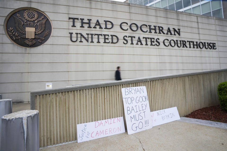 A few protest signs line the handicapped walkway at the Thad Cochran United States Courthouse in Jackson, Miss., Thursday, March 21, 2024. Federal sentencing continues with the fifth of six former Mississippi Rankin County law enforcement officers who committed numerous acts of racially motivated, violent torture on them in 2023. (AP Photo/Rogelio V. Solis)