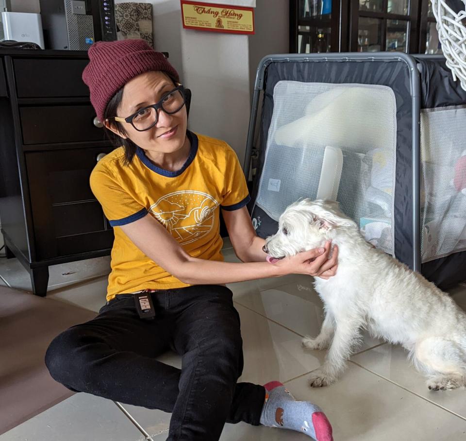 Kim Nguyen on the floor with a dog