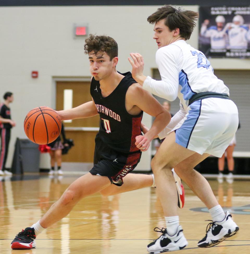 NorthWood's Ethan Wolfe (0) drives to the basket against Saint Joseph's Trey Place (22) during the Saint Joseph vs. NorthWood boys basketball game Tuesday, Jan. 17, 2023 at Saint Joseph High School.
