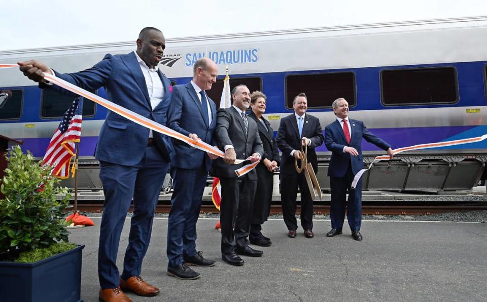 Funcionarios dan la bienvenida a los nuevos vagones de pasajeros con un corte de listón mientras Amtrak muestra sus nuevos vagones Venture para su línea San Joaquins en las instalaciones de mantenimiento ferroviario ACE en Stockton, California, el martes 5 de marzo de 2024.