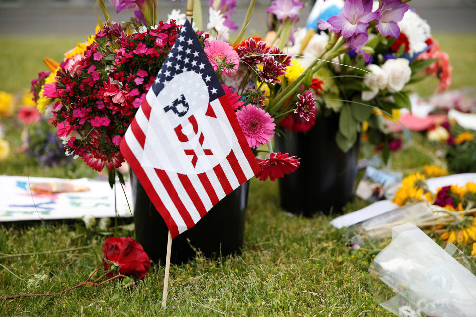 A flag stands at a makeshift memorial