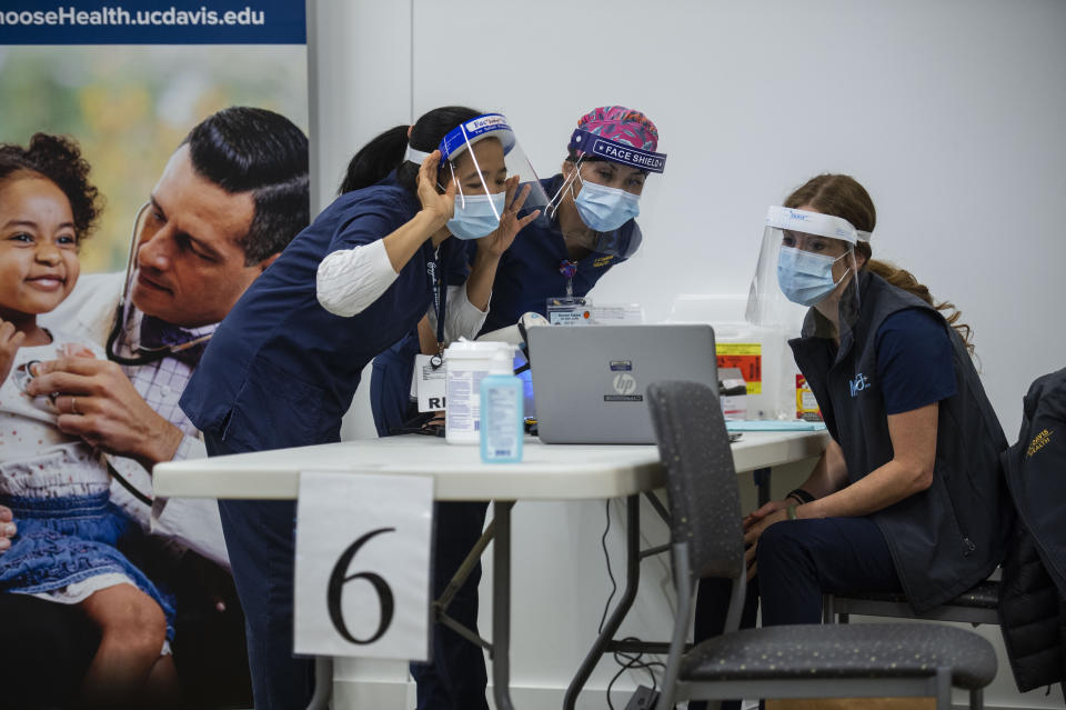 UC Davis Medical Center nurses, from left, Analyn Corpuz, Raenne Takara and Heather Donaldson review the process of inoculating with the Pfizer-BioNTech COVID-19 vaccine, Tuesday, Dec. 15, 2020 in Sacramento, Calif. (AP Photo/Hector Amezcua, Pool)