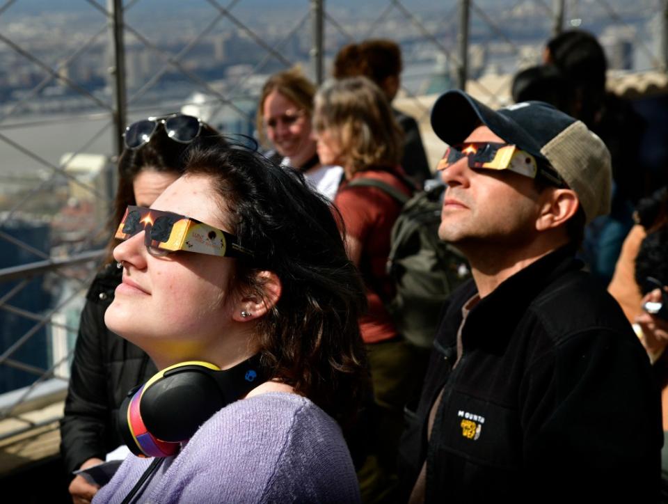 People gather to view the solar eclipse at the Empire State Building on Monday. Getty Images for Empire State Realty Trust