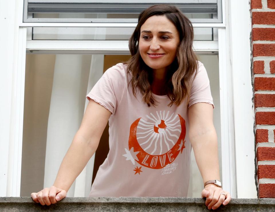 <p>Sara Bareilles smiles out of a window while filming a scene for the upcoming comedy series <i>Girls5eva</i> in N.Y.C. on Tuesday. </p>