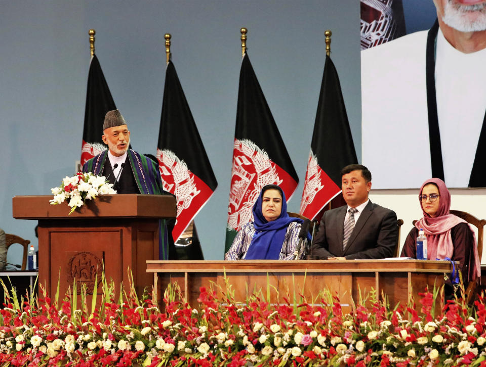 Former Afghan President Hamid Karzai, left, speaks on the last day of an Afghan Loya Jirga or traditional council, in Kabul, Afghanistan, Sunday, Aug. 9, 2020. The council concluded Sunday with hundreds of delegates agreeing to free 400 Taliban members, paving the way for an early start to negotiations between Afghanistan's warring sides. (AP Photo)