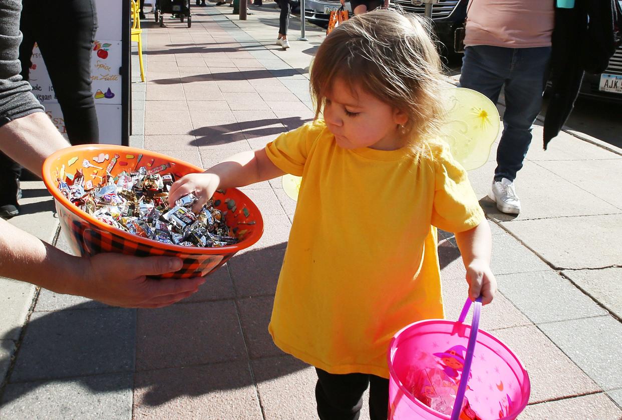 Sophie Bush, 3, collects candies at the downtown Trick or Treating event Friday, Oct. 28, 20022, in Ames, Iowa.