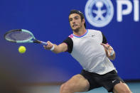 Lorenzo Musetti, of Italy, hits a return to Carlos Alcaraz, of Spain, during the Miami Open tennis tournament Tuesday, March 26, 2024, in Miami Gardens, Fla. (AP Photo/Marta Lavandier)