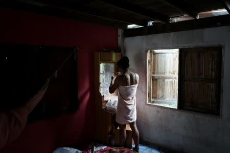 Muay Thai boxer Nong Rose Baan Charoensuk, 21, who is transgender, gets dressed at her house in Phimai district in Nakhon Ratchasima province, Thailand, July 18, 2017. REUTERS/Athit Perawongmetha