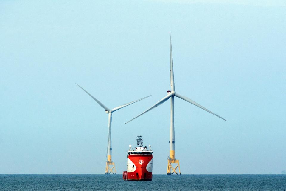 A ferry navigates past wind turbines off the coast of Aberdeen in the North East of Scotland, on April 29, 2022. (Photo by Andy Buchanan / AFP) (Photo by ANDY BUCHANAN/AFP via Getty Images)