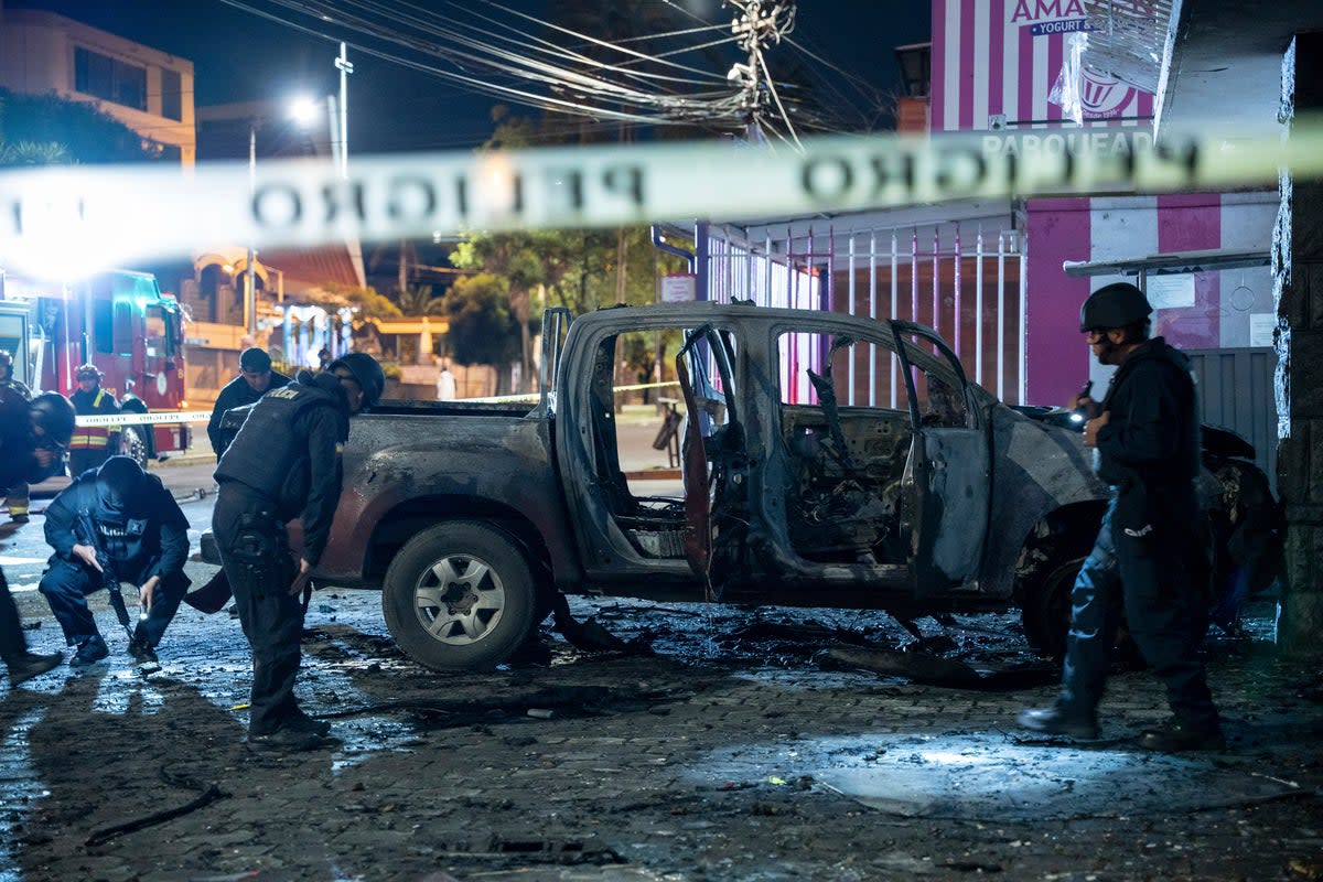 Police inspect a truck that exploded outside an office used by the government's National Service for Attention for People Deprived of Liberty (SNAI), which runs the jail system, in Quito (AP)