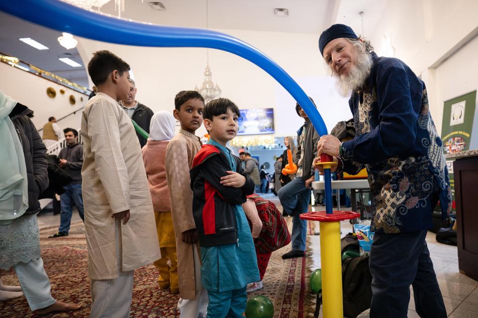 Emad The Twister makes balloon animals for children during the Eid festival held Saturday at the Worcester Islamic Center.