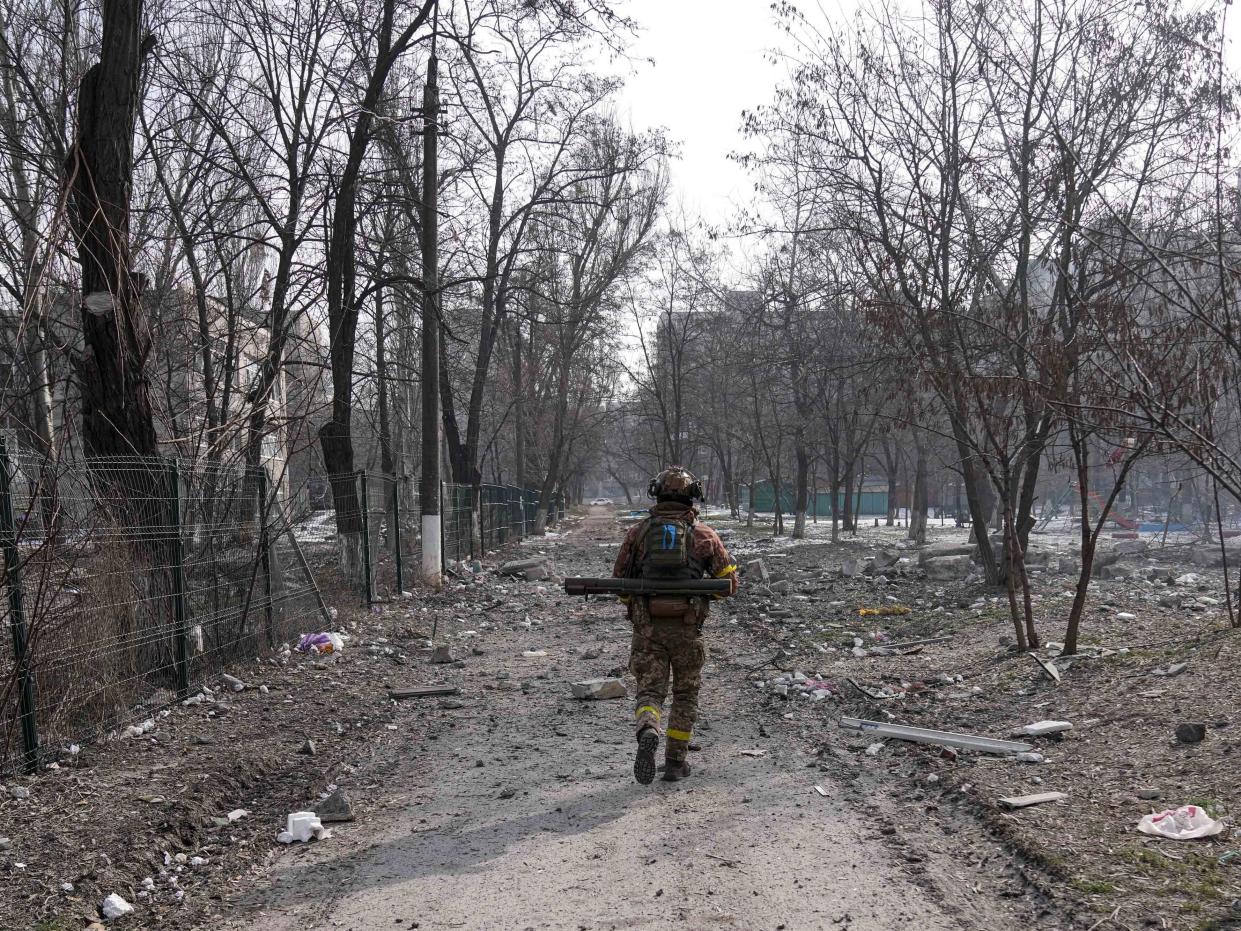 A Ukrainian serviceman walks near the position he was guarding in Mariupol, Ukraine, Saturday, March 12, 2022.