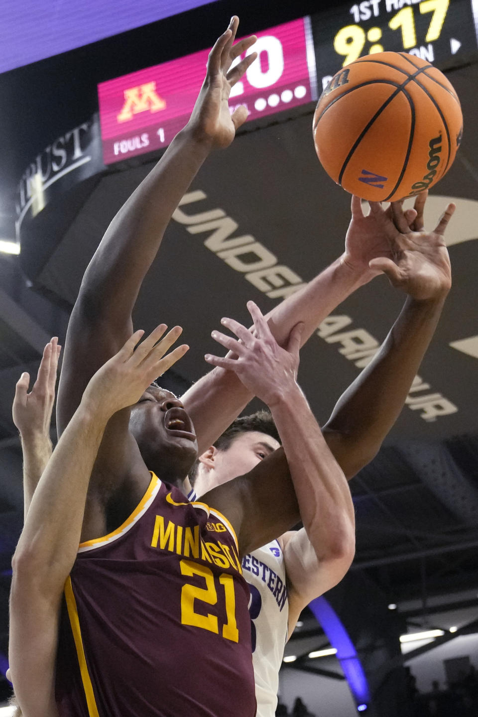 Minnesota forward Pharrel Payne (21) battles for a rebound against Northwestern guard Ryan Langborg, left, and guard Brooks Barnhizer, right, during the first half of an NCAA college basketball game in Evanston, Ill., Saturday, March 9, 2024. (AP Photo/Nam Y. Huh)