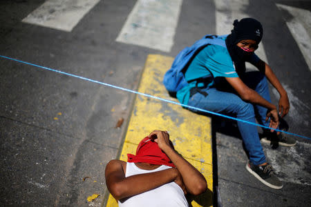 Demonstrators rest as they block a street at a rally against Venezuela's President Nicolas Maduro's government in Caracas, Venezuela August 8, 2017. REUTERS/Andres Martinez Casares