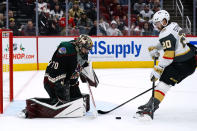 Arizona Coyotes goaltender Karel Vejmelka (70) makes a save on Vegas Golden Knights center Chandler Stephenson (20) during the second period of an NHL hockey game Friday, Dec. 3, 2021, in Glendale, Ariz. (AP Photo/Ross D. Franklin)