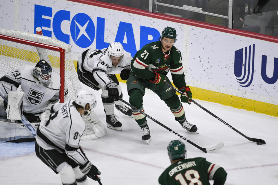 Minnesota Wild right wing Brandon Duhaime (21) looks to pass the puck as Los Angeles Kings defenseman Mikey Anderson reaches to block the puck next to goalie Pheonix Copley during the first period of an NHL hockey game Tuesday, Feb. 21, 2023, in St. Paul, Minn. (AP Photo/Craig Lassig)