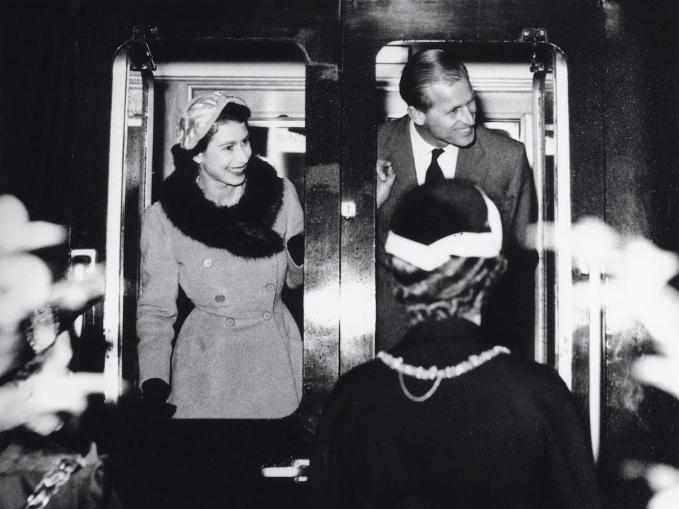 The Queen and Duke of Edinburgh bid farewell to onlookers as the Royal Train departs from Sunderland station in the UK on October 29, 1954.